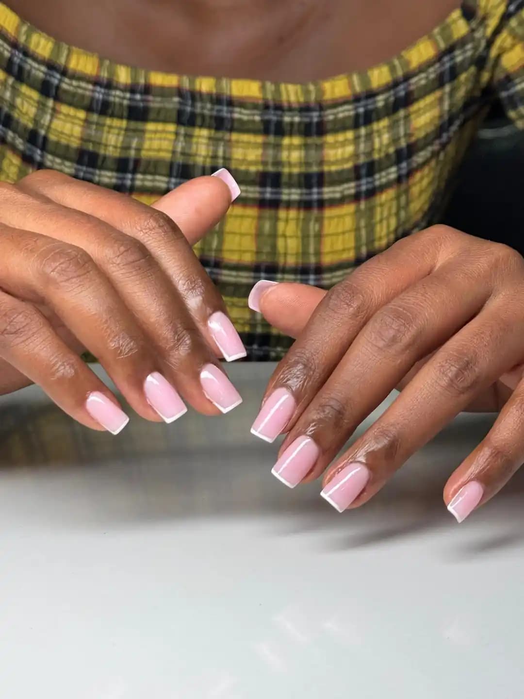 Gel overlay manicure close-up with soft pink square nails
